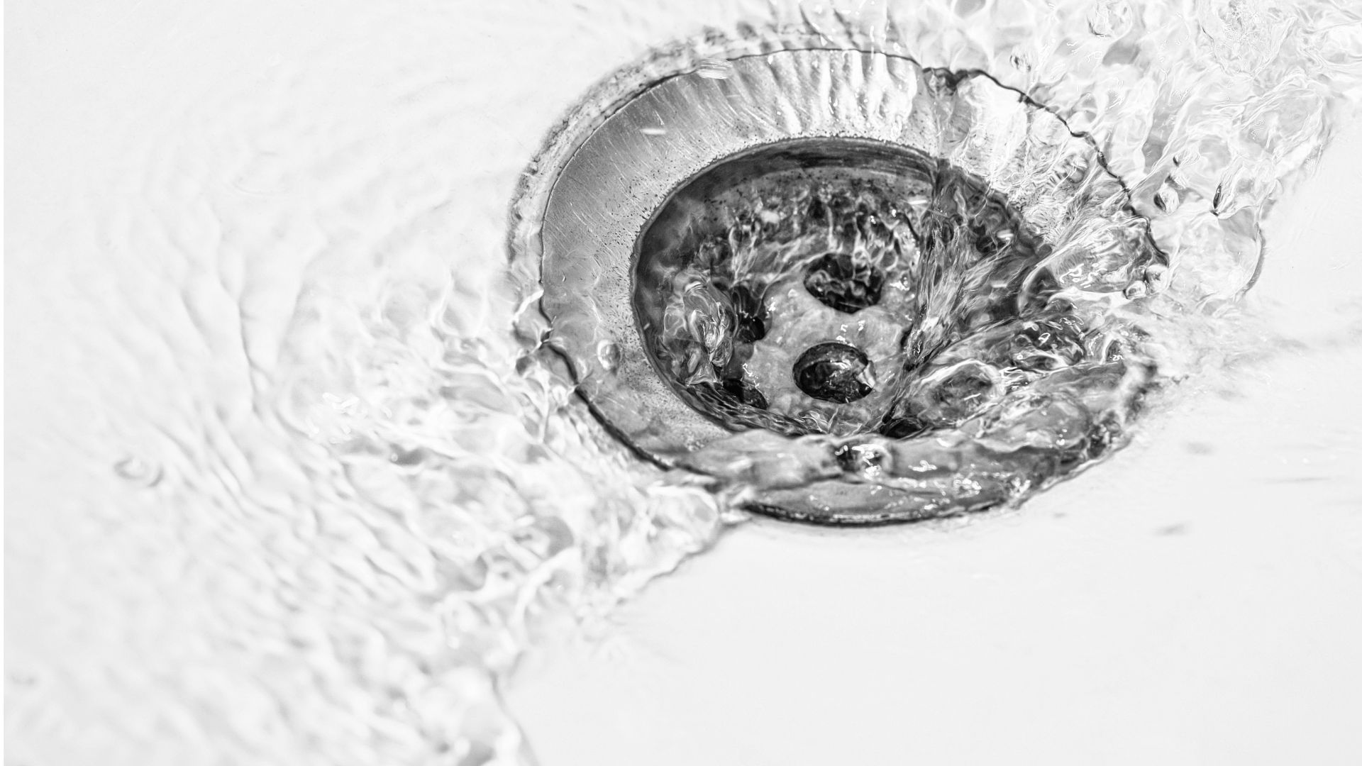 Water droplet splashing into circular basin creating intricate ripple patterns