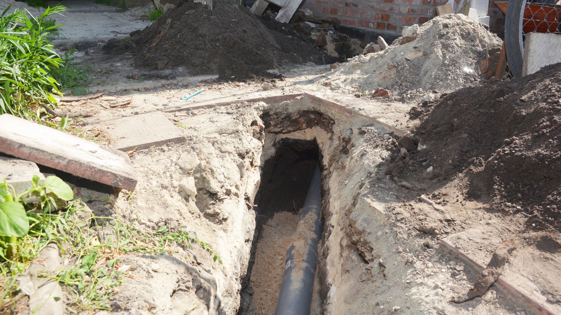 Underground pipe installation in construction site with exposed trench